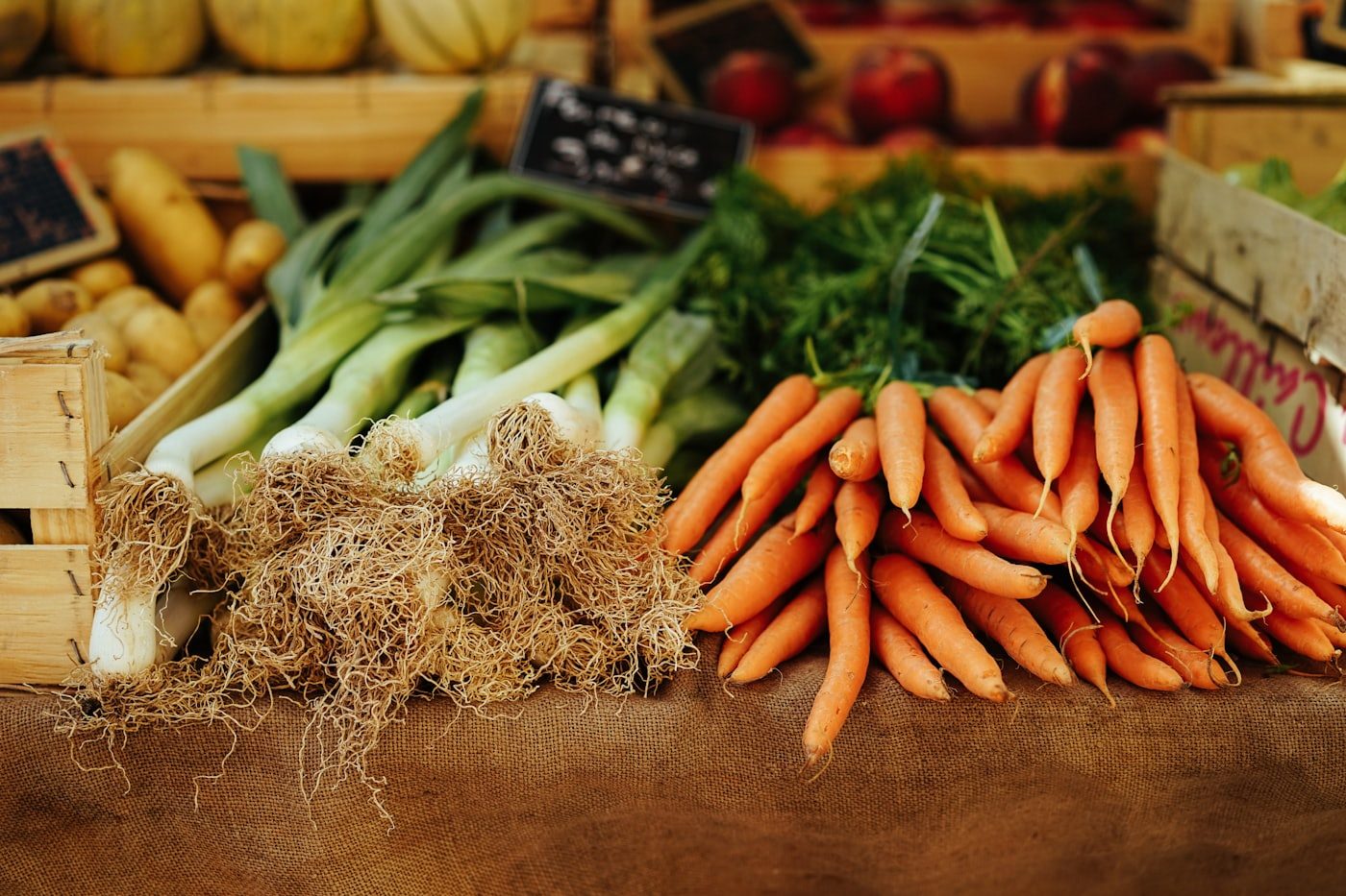 Crates of carrots and leeks at a market stall